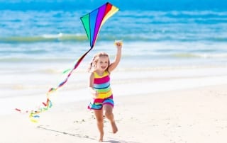 Photo of a Young Girl Holding a Kite—Good, Old-Fashioned Beach Fun!