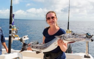 Photo of a Woman Holding a Mackerel on One of the Best Fishing Charters in Myrtle Beach.